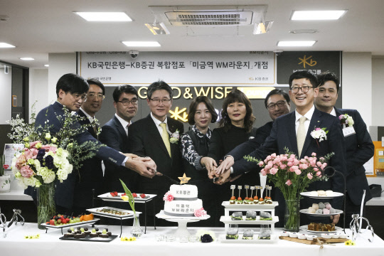 김효종 KB국민은행 성남지역영업그룹 대표(왼쪽에서 네번째)와 이재형 KB증권 WM총괄본부장(오른쪽에서 두번째), 임직원들이 지난 4일 '미금역WM라운지' 개점을 기념하며 케이크를 자르고 있다. <KB증권 제공>